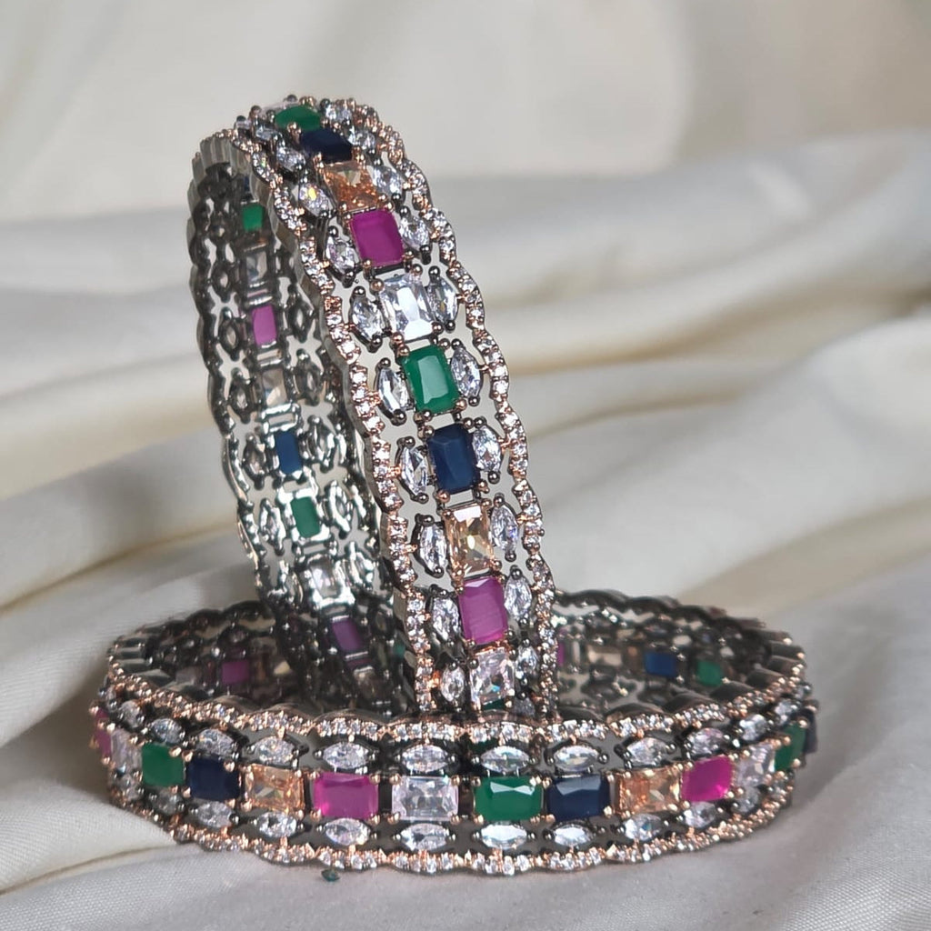 Decorative snake-shaped object with multicolored gemstones on a white fabric background