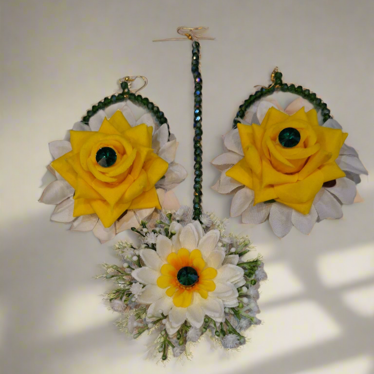 Pair of earrings with yellow and white floral designs on a light background