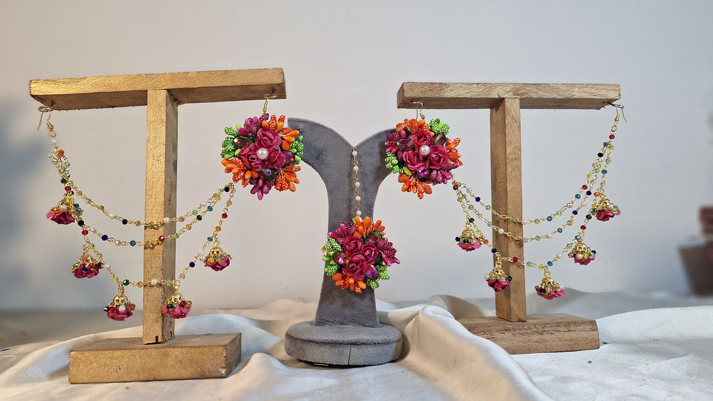 A detailed close-up shot showing the variety of vivid artificial focal flowers, elegant tracking chains, and matching bindiya on the Colour Bloom set.