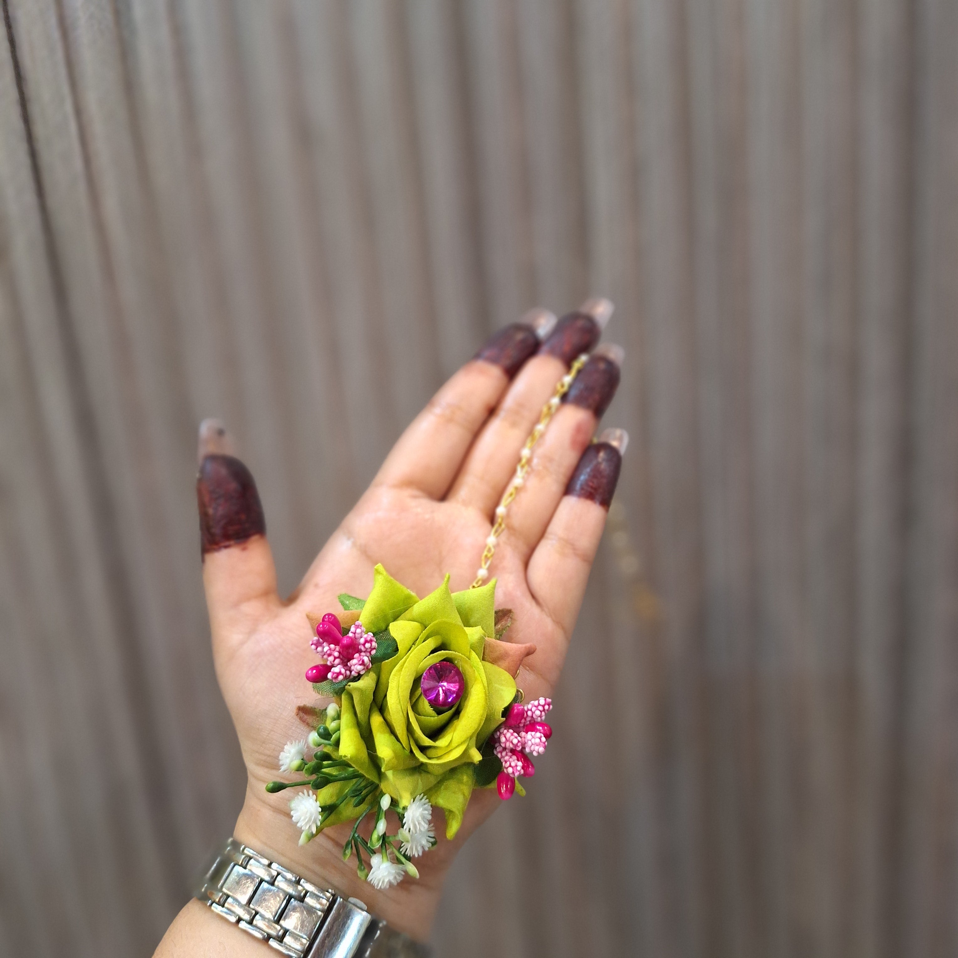 Hand holding a small bouquet of flowers against a wooden background