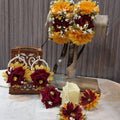 A collection of artificial floral jewelry including a hairpiece and earrings, with velvet roses, mustard chrysanthemums, and baby's breath.